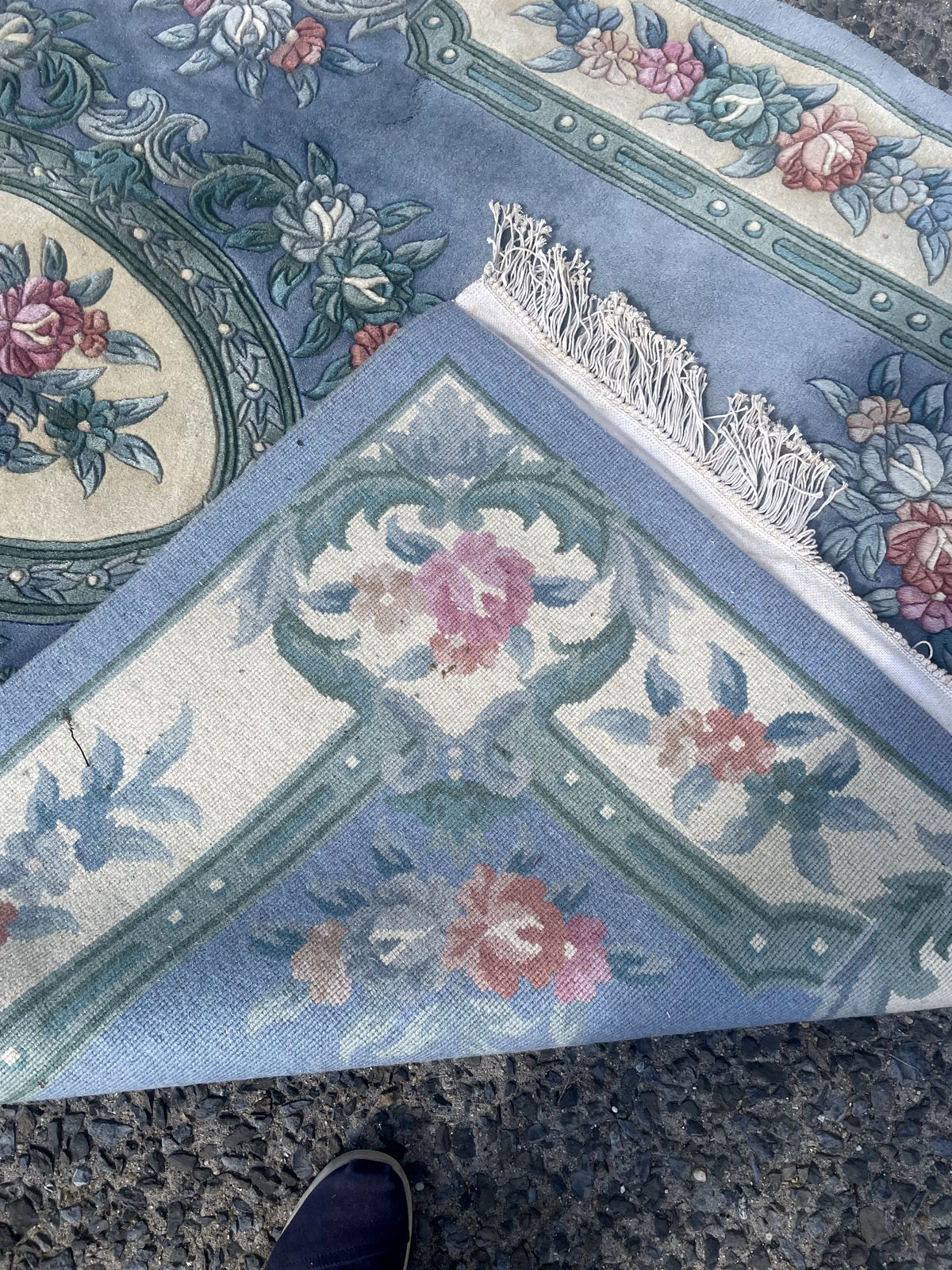 Blue pile shading beside sculpted rose bouquets and the geometric inner border.