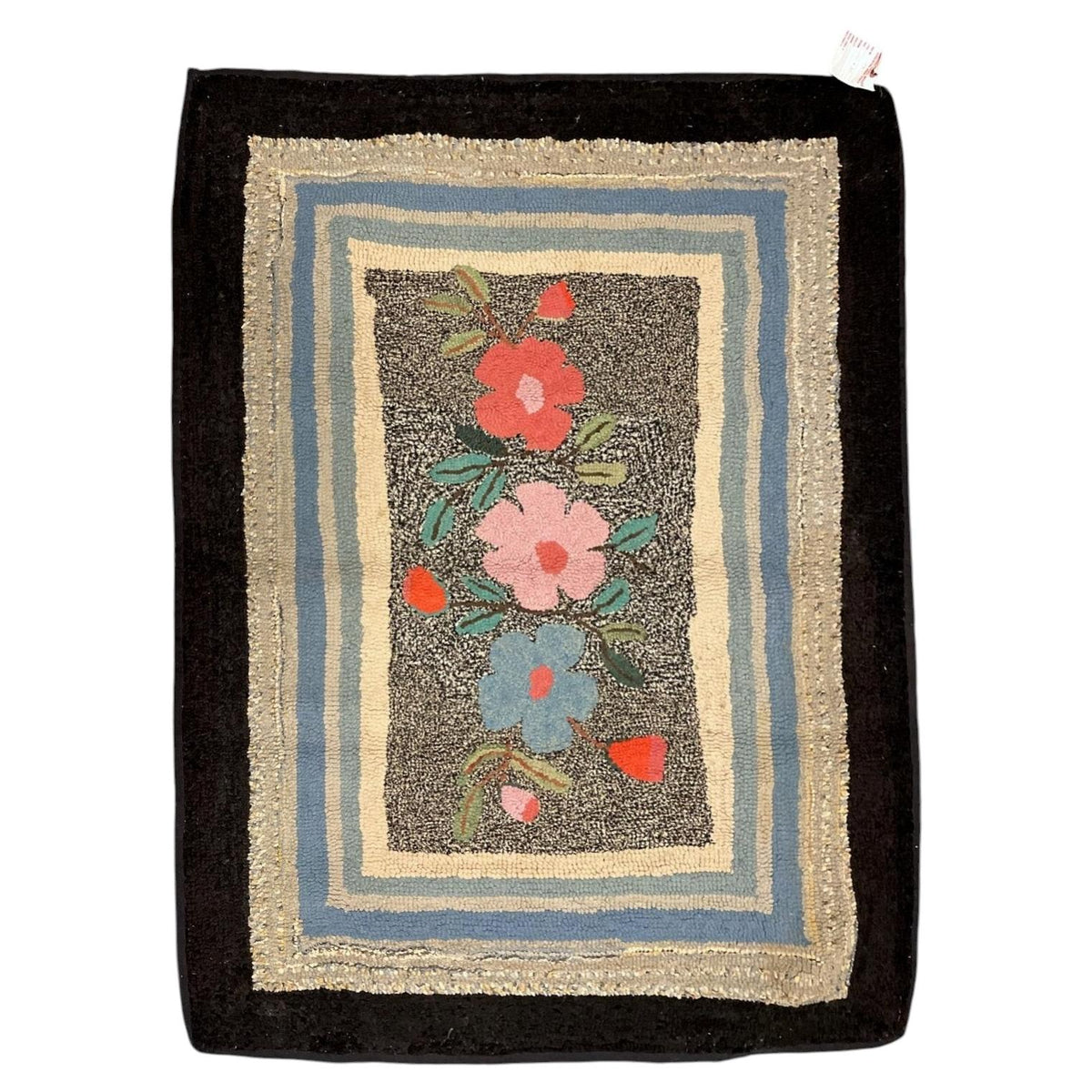 American hooked wool rug with three colourful flowers, layered pastel borders and a broad black frame.
