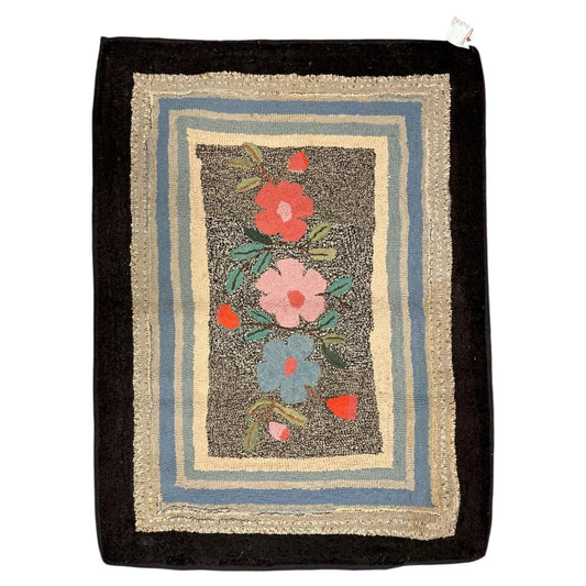 American hooked wool rug with three colourful flowers, layered pastel borders and a broad black frame.