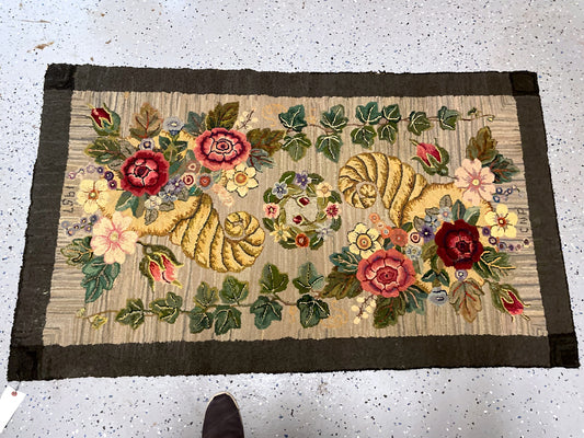Hooked-in 1957 date beneath burgundy, cream and yellow flowers on the beige ground.
