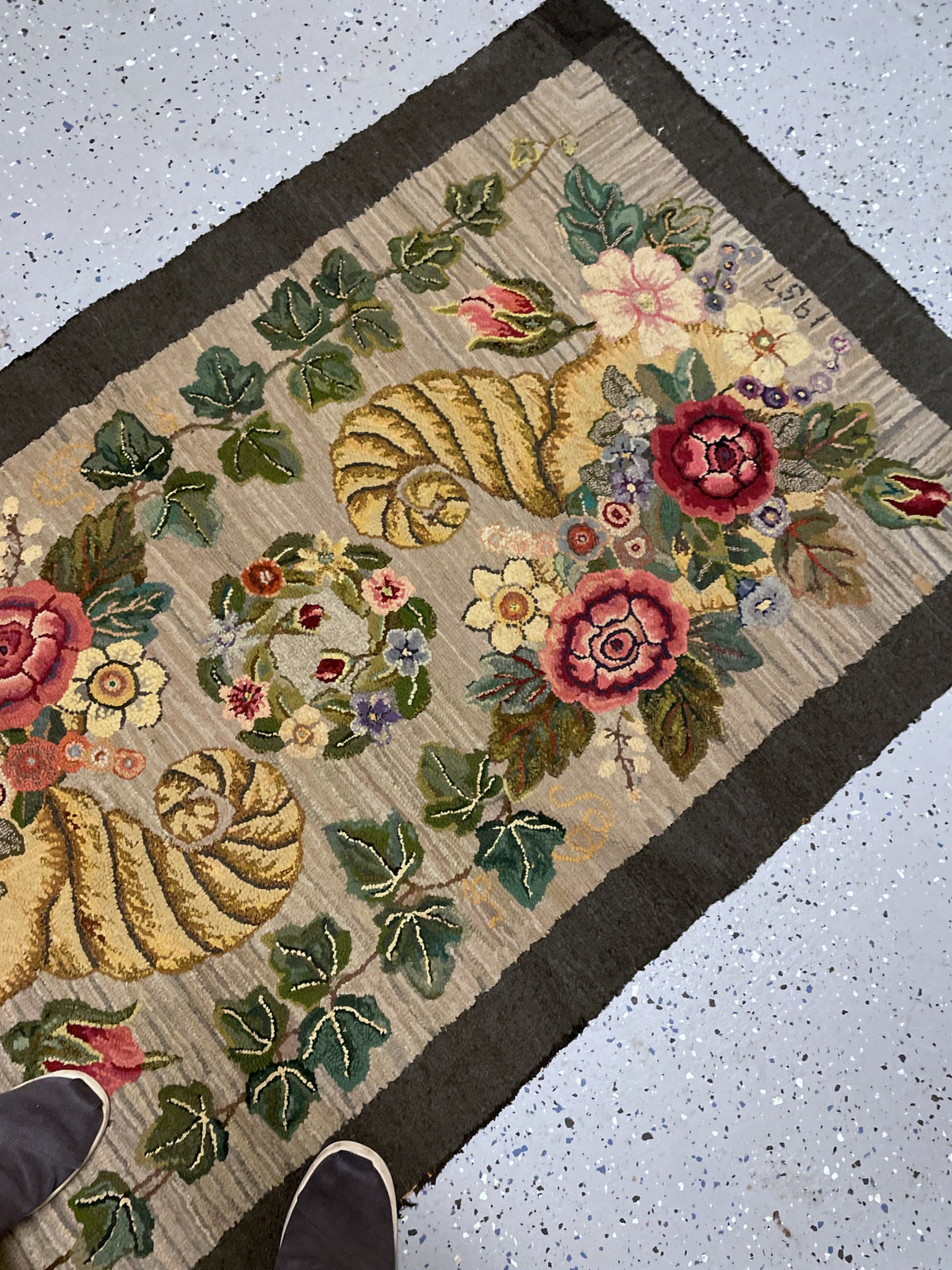 Golden cornucopia and floral bouquet above hooked initials appearing to read CMP.