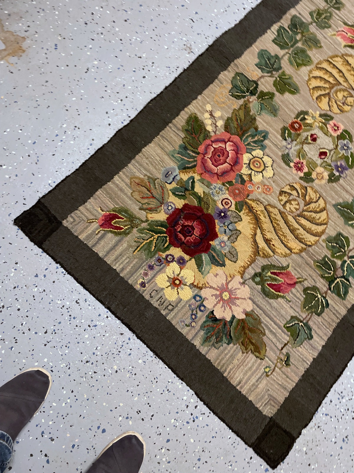 Full rug view showing opposing floral cornucopias and darker corner squares.