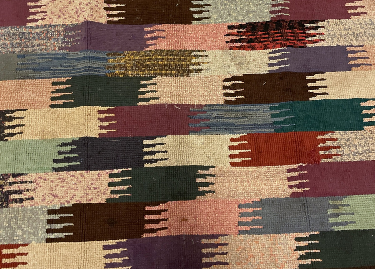 Central pattern detail with cream, peach, plum and mottled brown hooked sections.