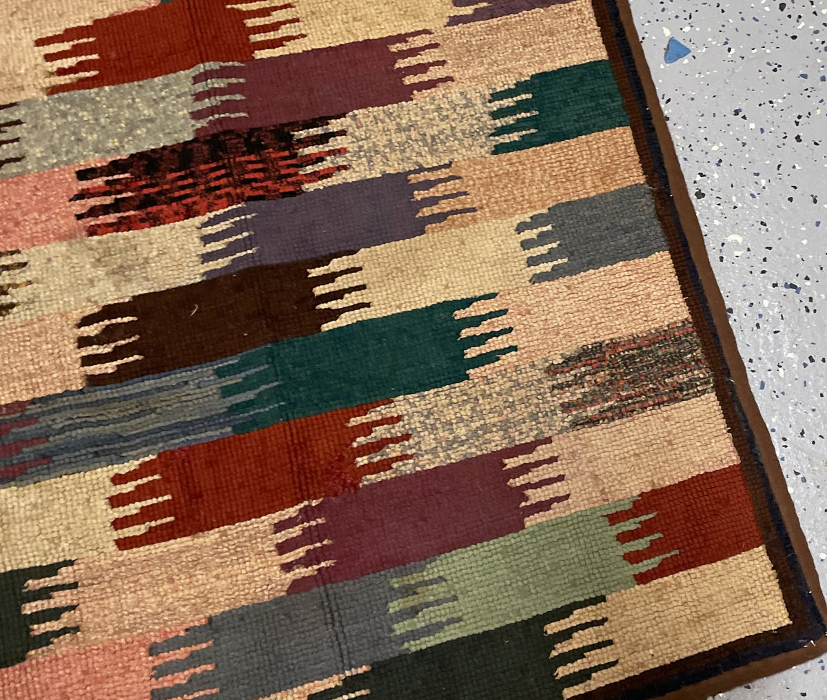 Horizontal rug view with staggered colour blocks and slightly wavy bound edges.