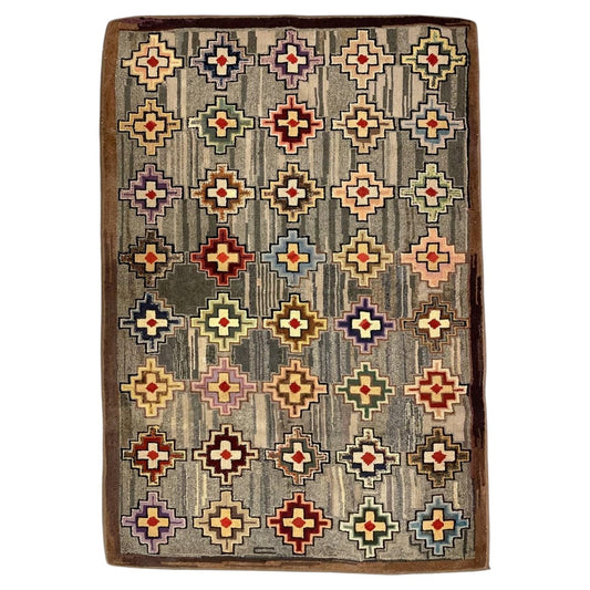 American hooked wool rug with colourful stepped-cross medallions, a striated grey field and brown border.
