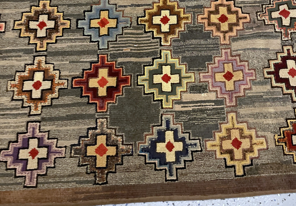 Detailed hooked surface with sage, burgundy, blue and lilac cross-shaped motifs.
