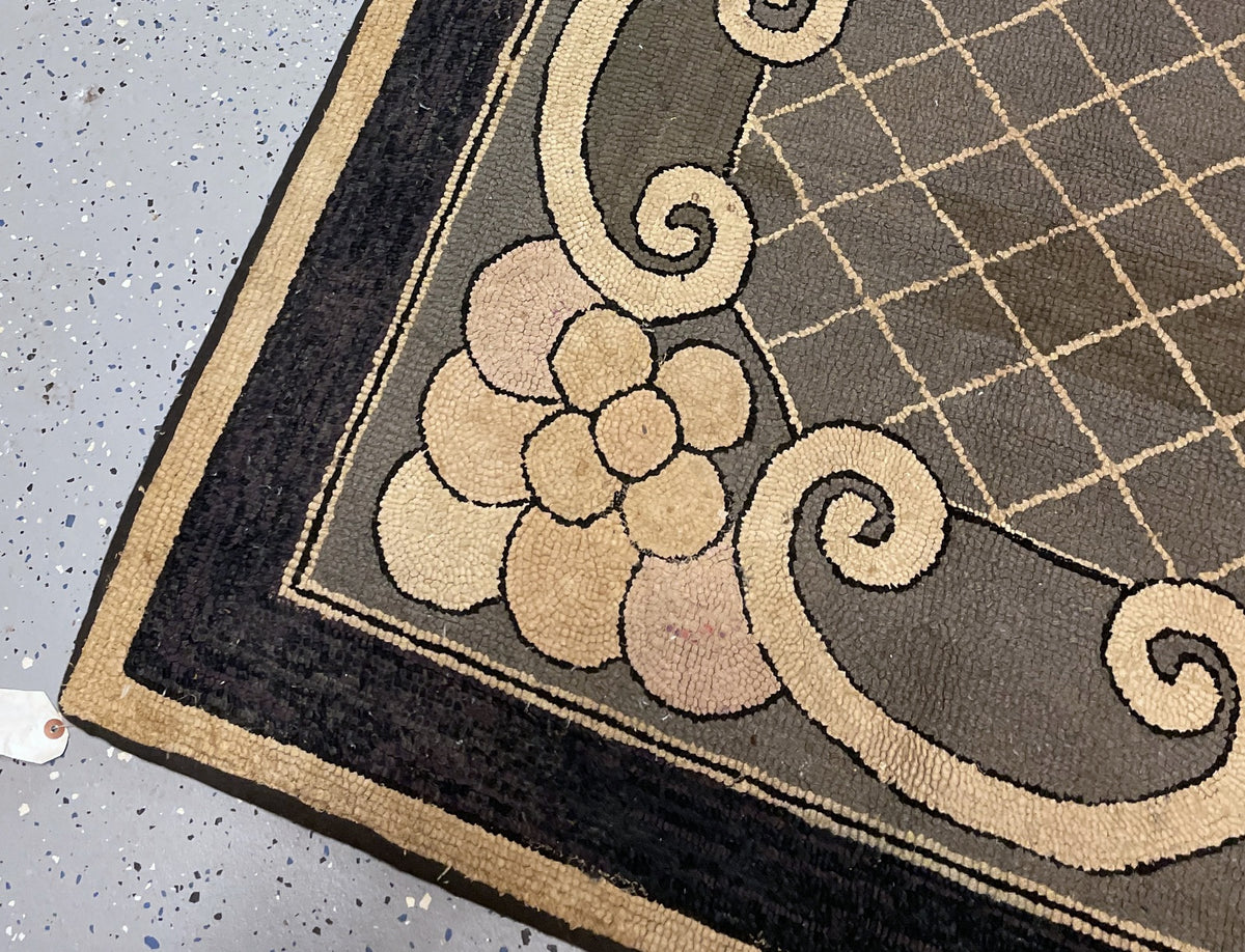 Hooked scrolls and circular accent beneath the lattice field, framed by a broad dark border.