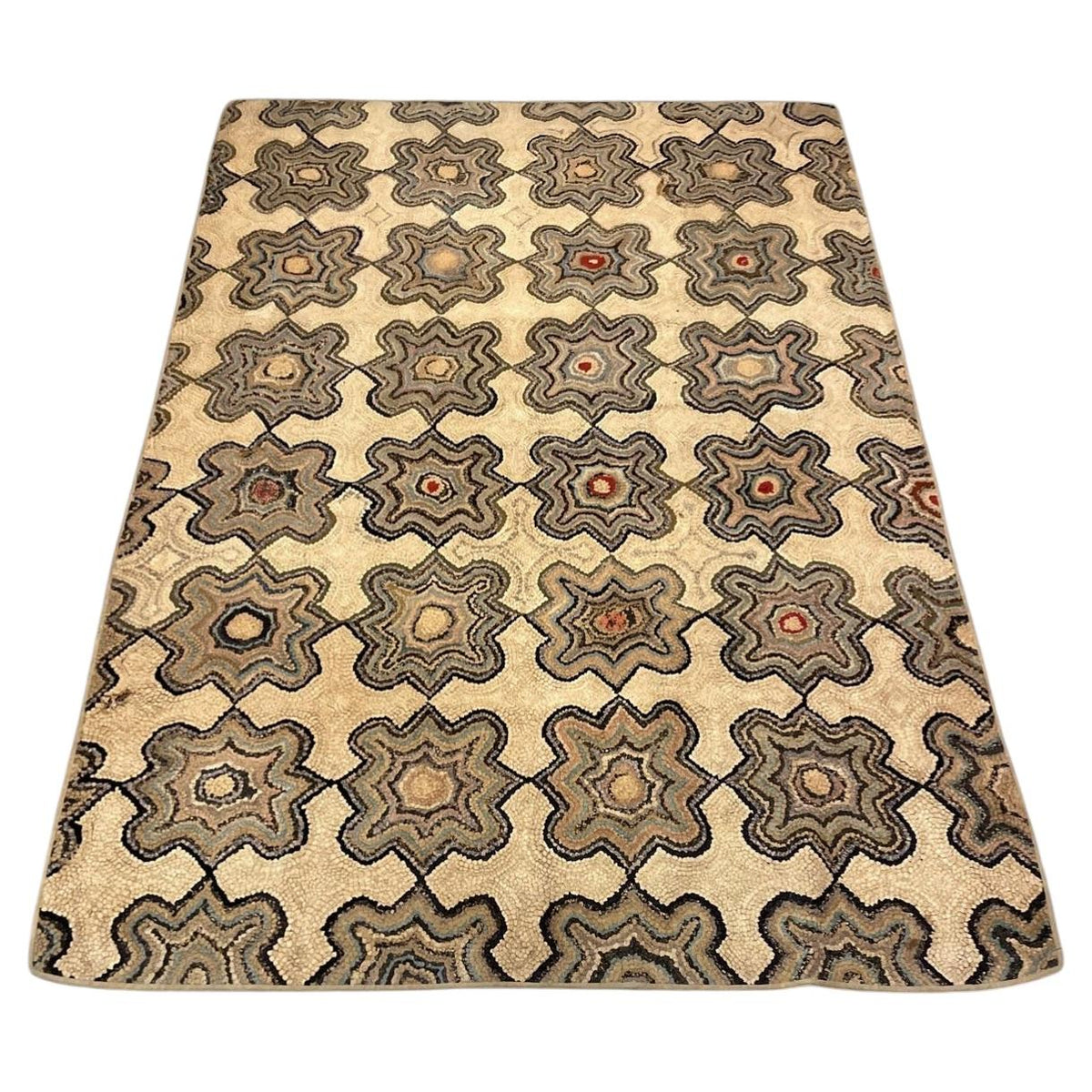 American hooked cotton rug with linked grey star-shaped rosettes on a warm cream ground.