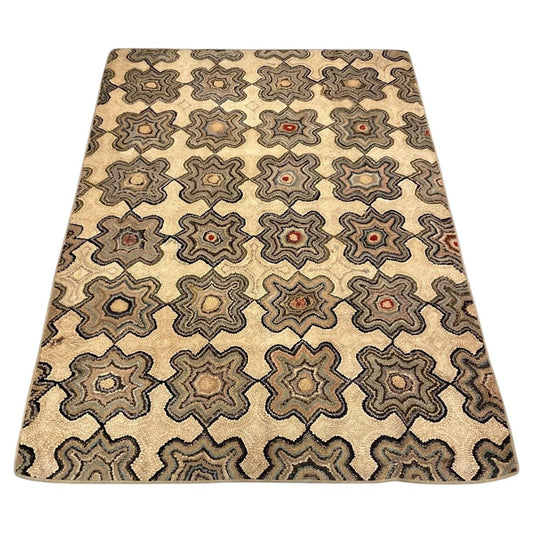 American hooked cotton rug with linked grey star-shaped rosettes on a warm cream ground.