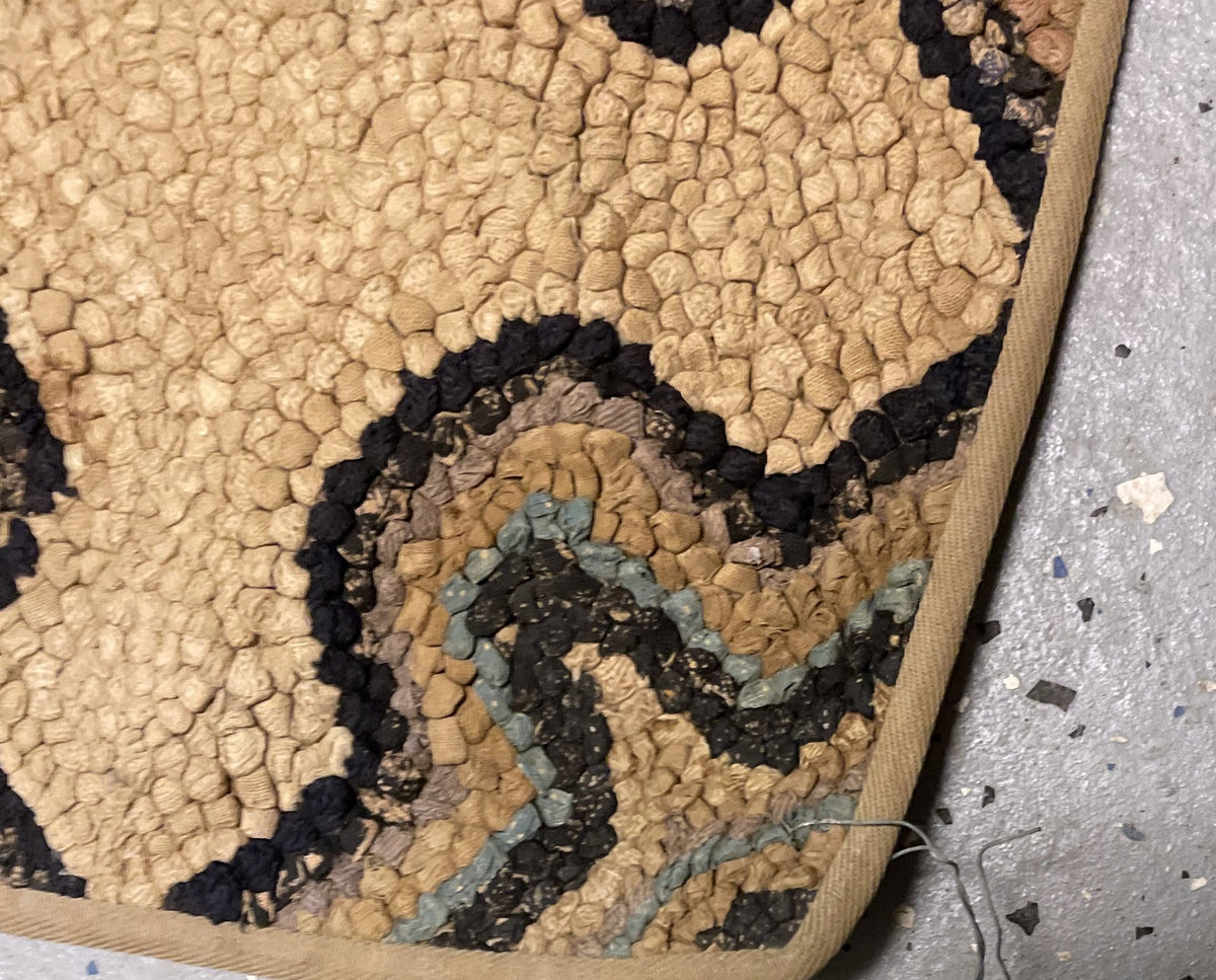 Folded corner revealing the reverse pattern and narrow beige perimeter binding.