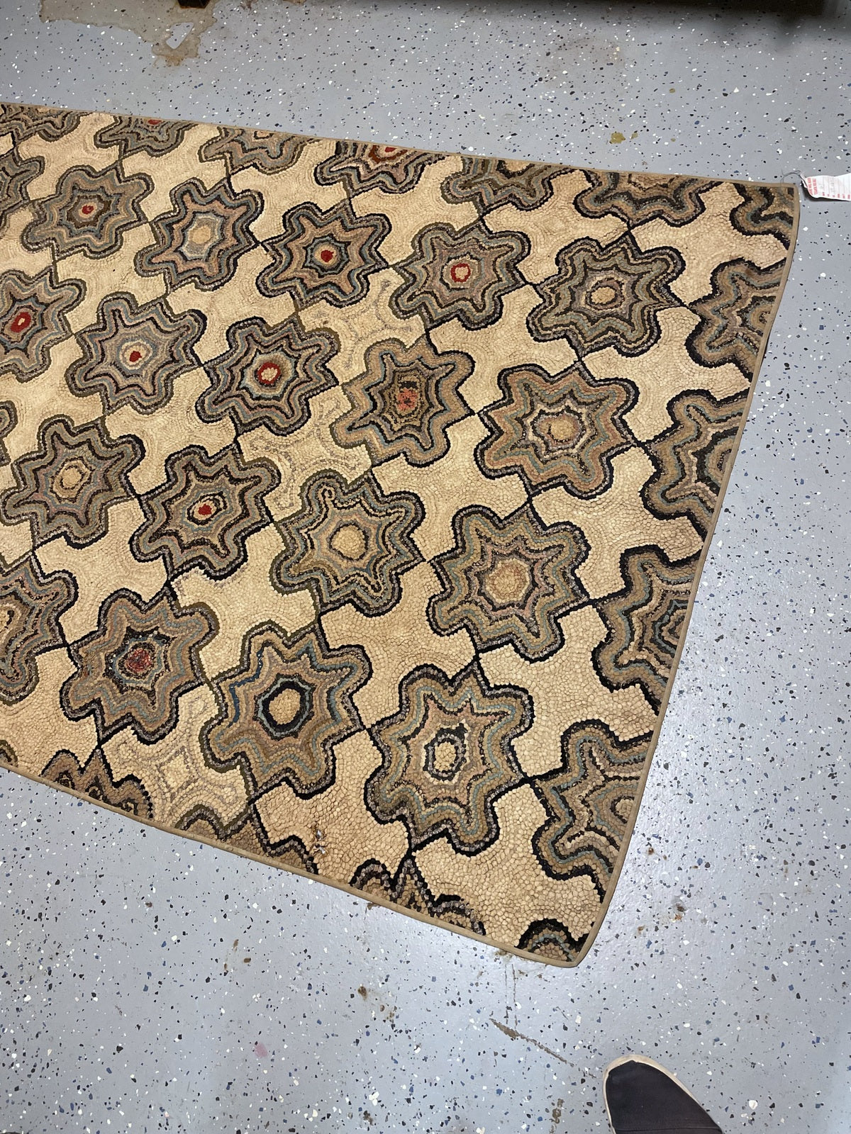 Close view of the folded rug showing concentric rosettes and variations in hooked texture.