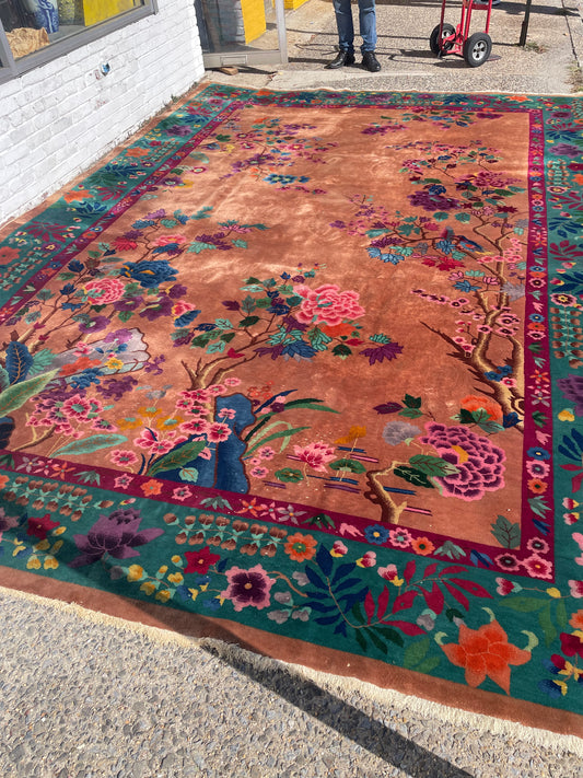 Angled full view of the 10 by 14 foot Chinese floral rug with pale fringed ends.