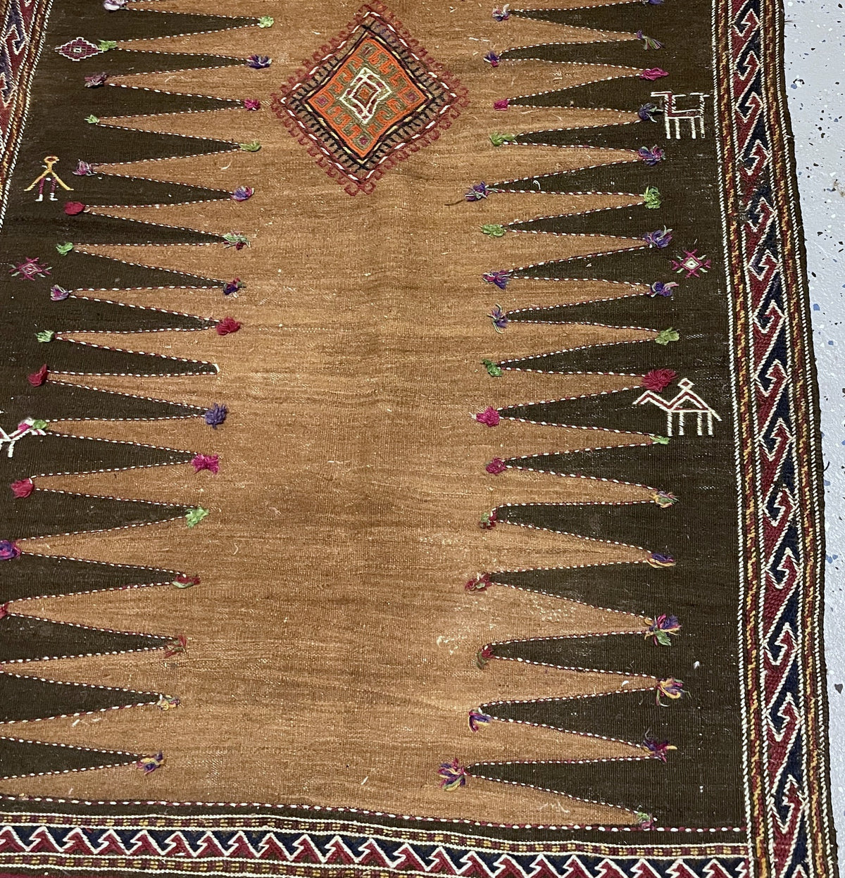 Upper kilim section showing zigzag end bands, burgundy edging and uneven pale fringe.