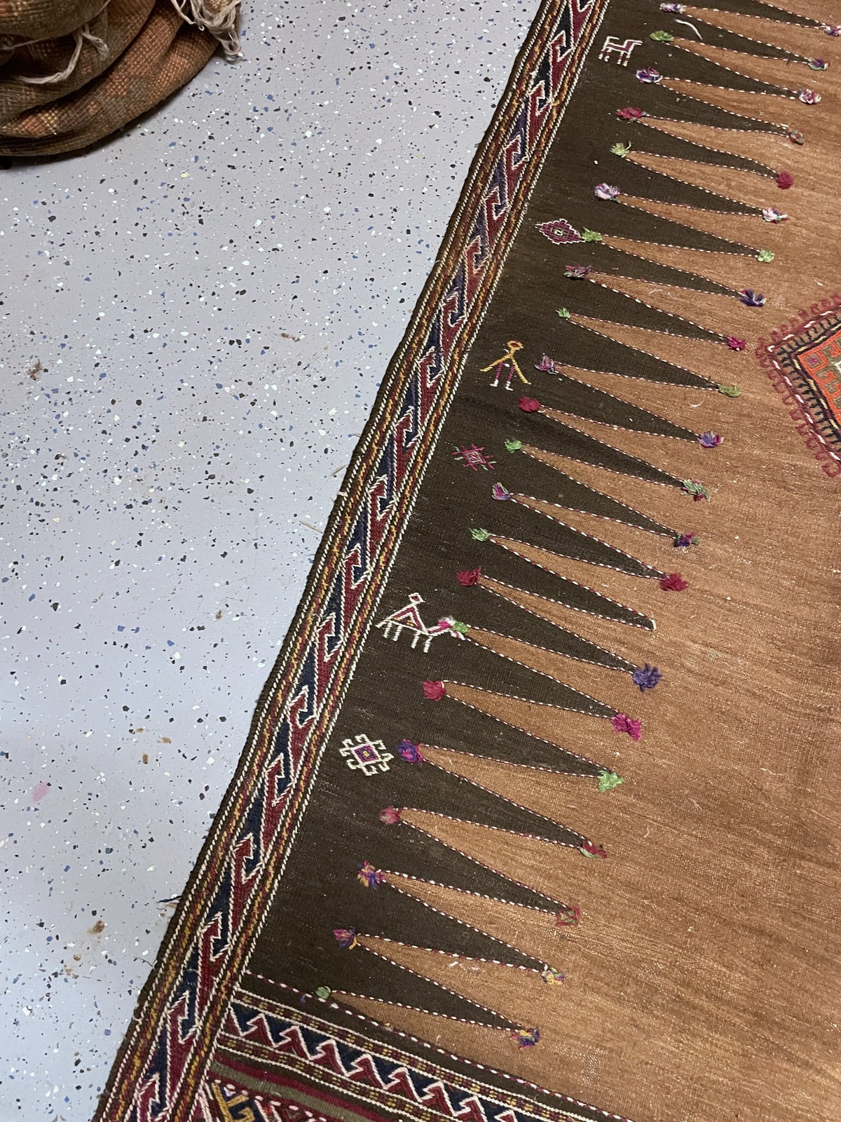 Full-length handwoven kilim showing both patterned end panels and the open camel centre.