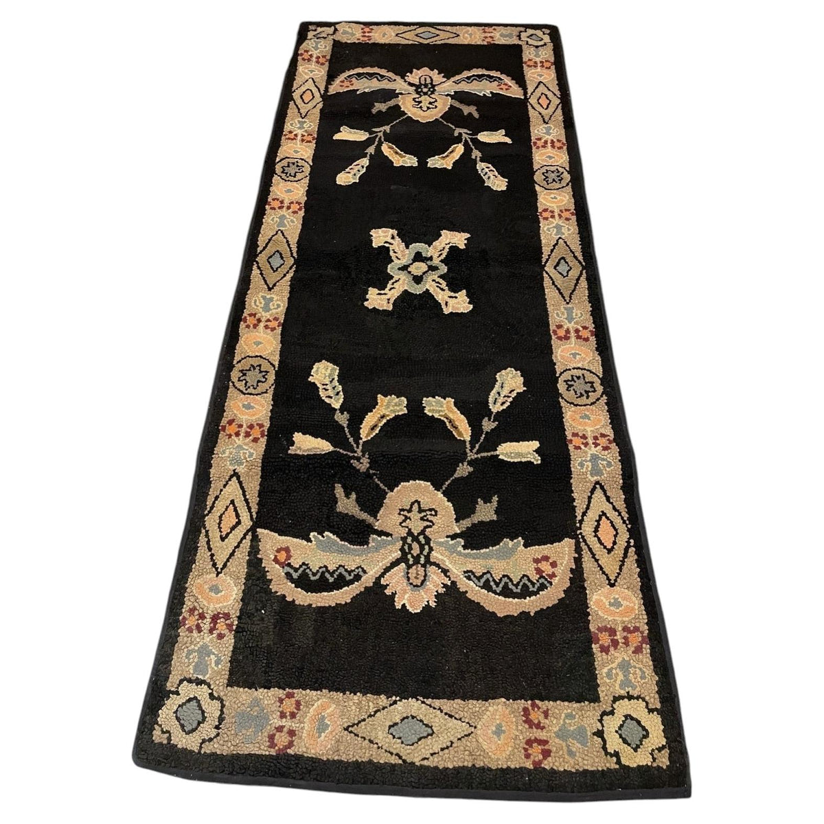 Full American hooked cotton runner with black field, mirrored floral motifs and cream geometric border.