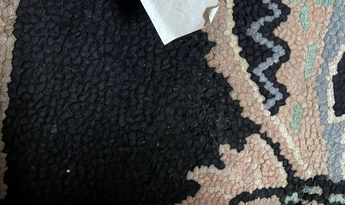Full-length black floral runner with a small central cross ornament and pale patterned border.
