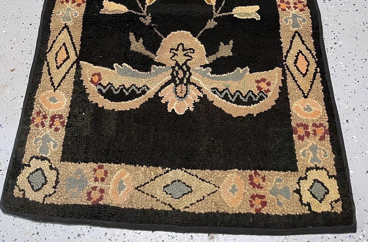 Close-up of black cotton loops beside a peach floral motif and blue-grey zigzag detail.