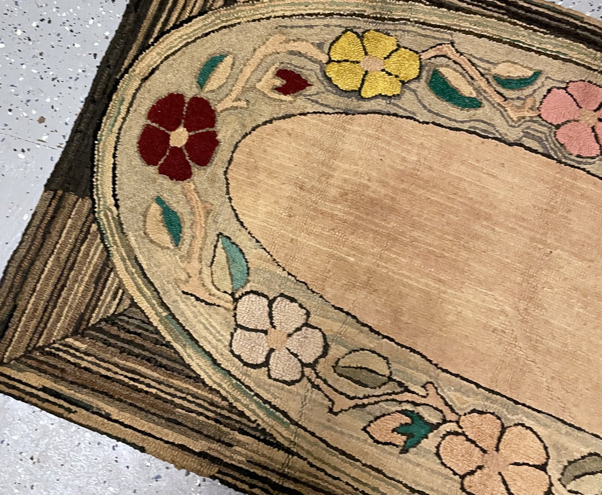 Angled upper corner showing the oval floral surround, striped bands and dark bound edge.