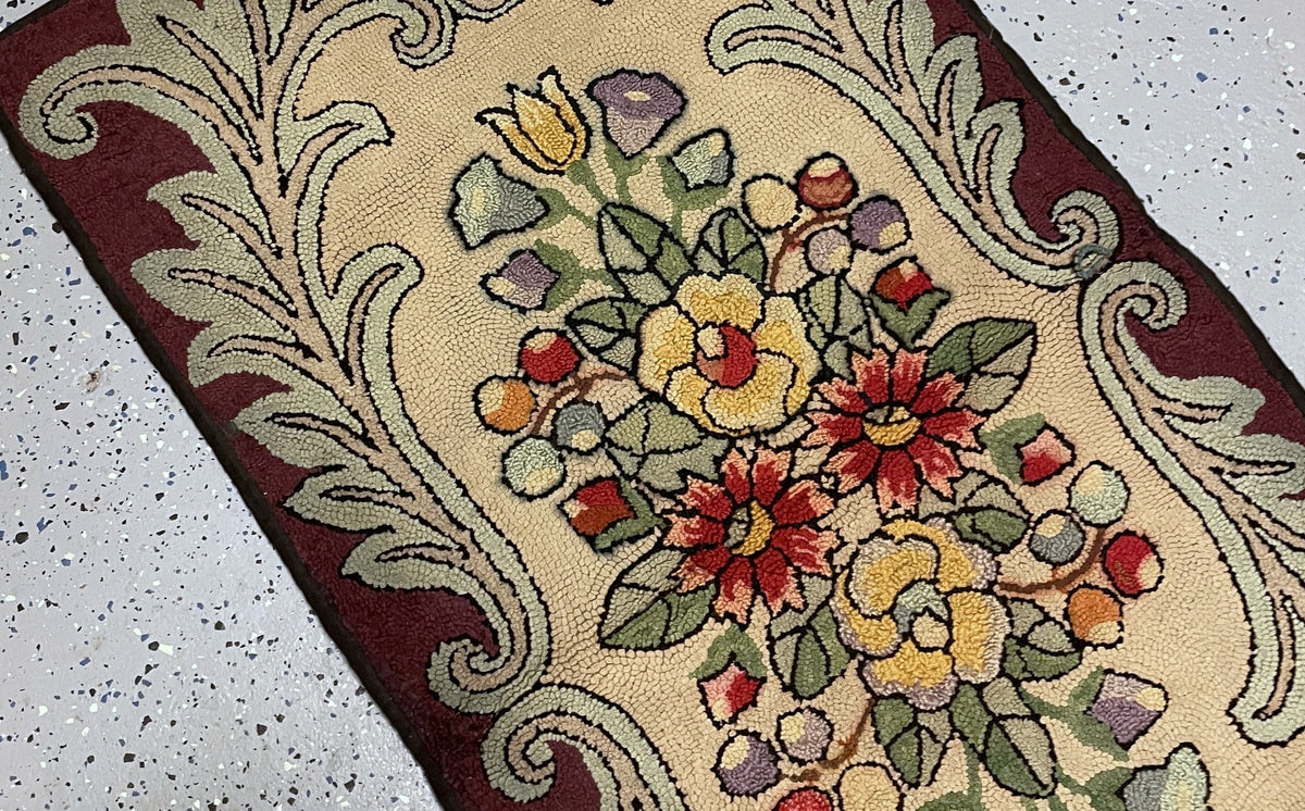 Detailed red daisy-like flowers and yellow blooms among dark-outlined sage leaves on the cream wool field.