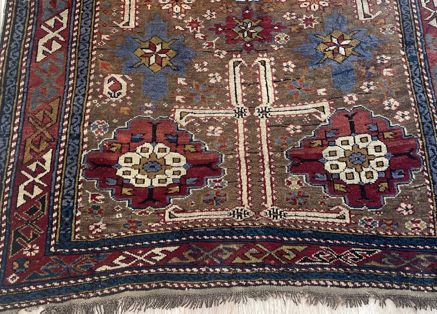 Late 19th century tribal rug from Shirvan district with tobacco brown field and madder red medallions on floor

