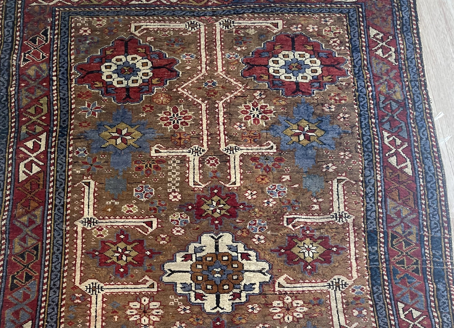 Close-up of antique Kuba rug displaying intricate geometric medallions and ancient tribal symbols

