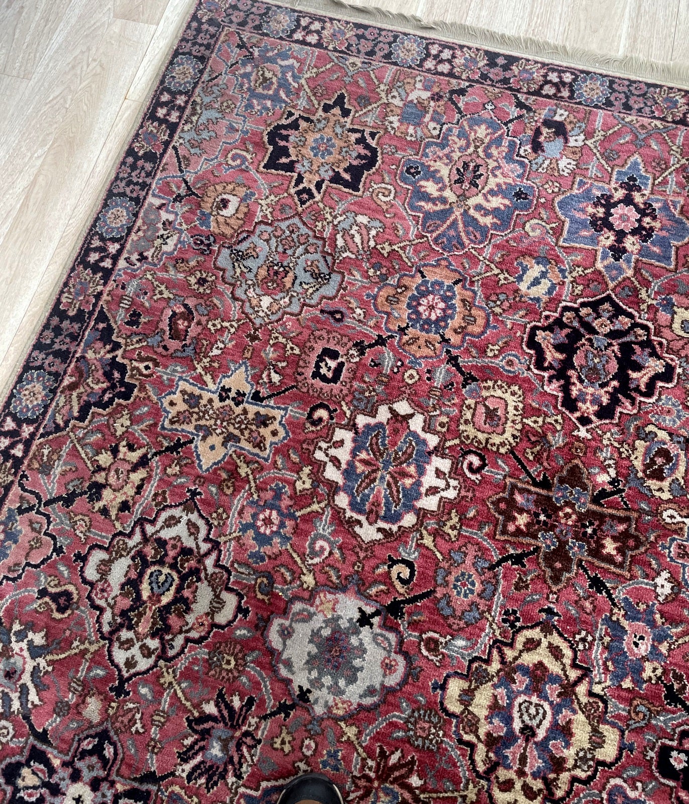 American Karastan "Wonder Rug" with rose-madder field and ornate central medallion on floor

