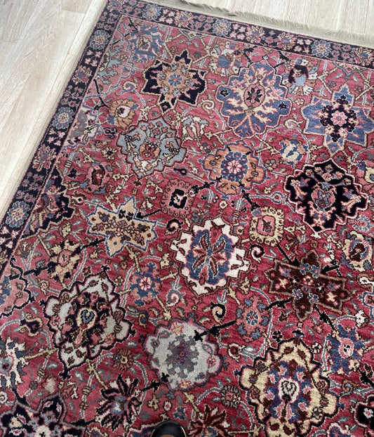 American Karastan "Wonder Rug" with rose-madder field and ornate central medallion on floor

