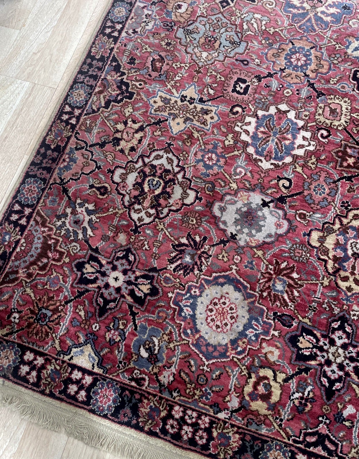 Close-up of vintage Karastan rug displaying intricate floral sprays palmettes and scrolling vines

