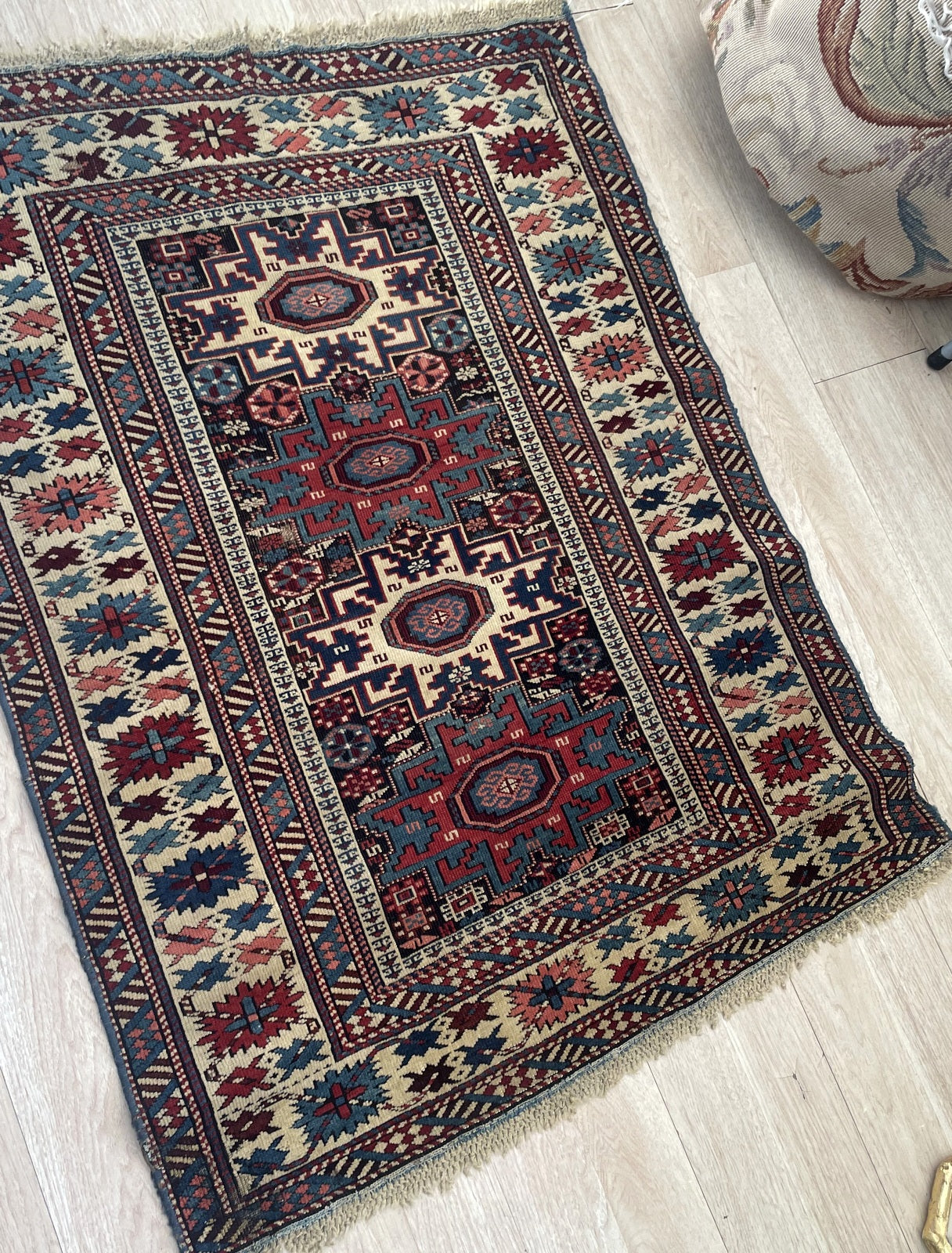 Late 19th century tribal rug from Dagestan region with deep indigo field and madder red stars on floor


