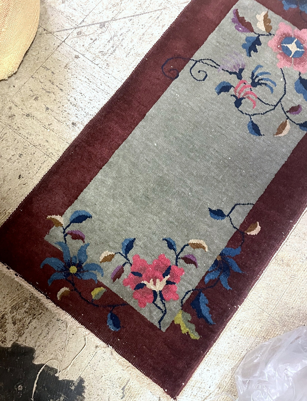 Vintage Chinese Nichols style rug from Tientsin region with oxblood red border and corner florals on floor


