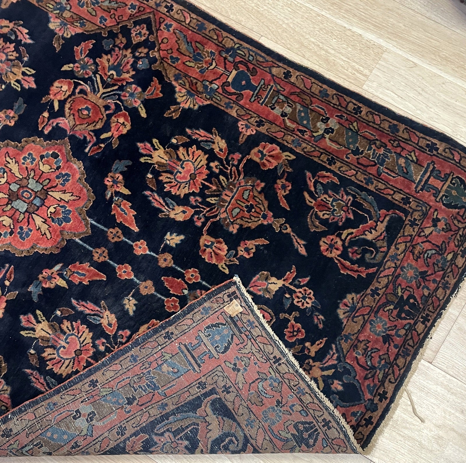 Close-up of antique Sarouk Mahajiran rug displaying sophisticated flowering vases and botanical motifs

