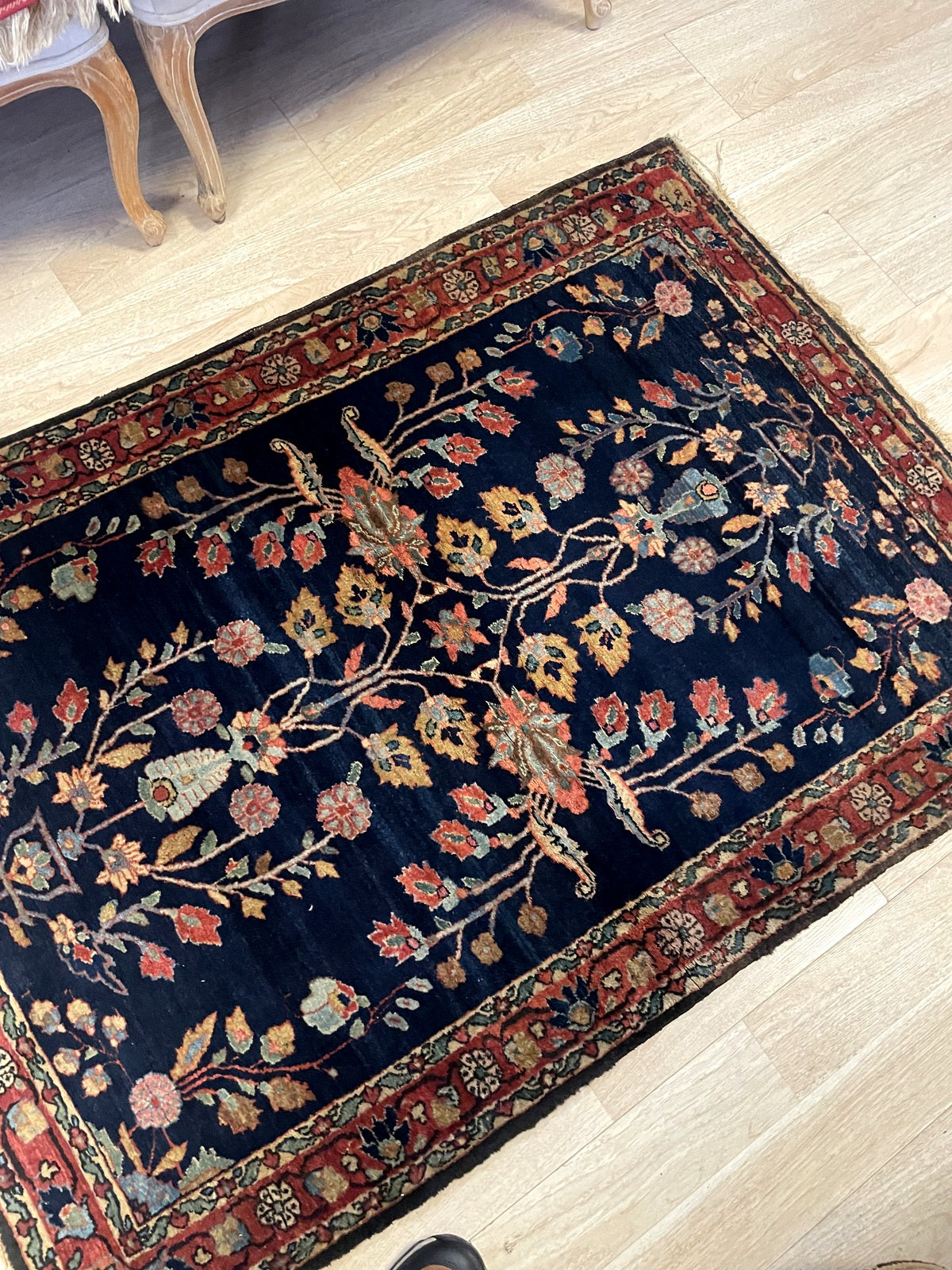 Close-up of antique Sarouk Mahajiran rug displaying flowering urns and delicate vines in soft terracotta

