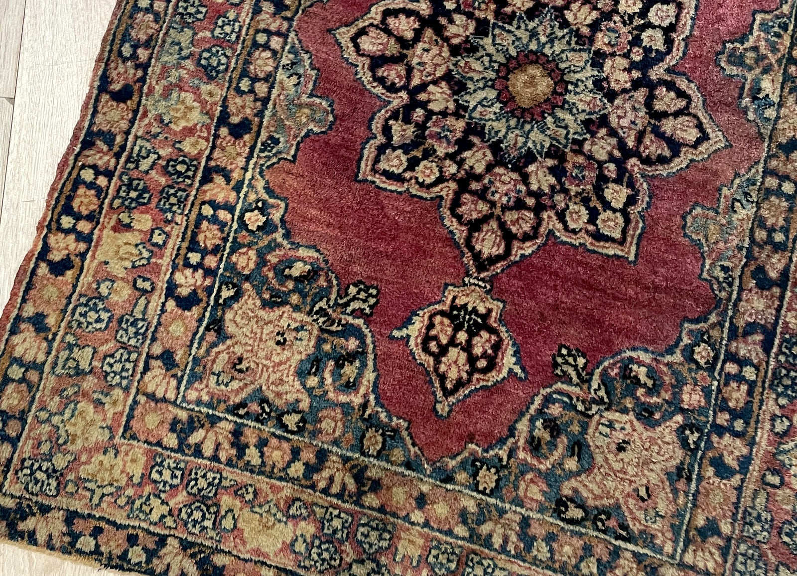 Close-up of exquisite Kerman Lavar rug showcasing masterful Ogee medallion and delicate palmettes

