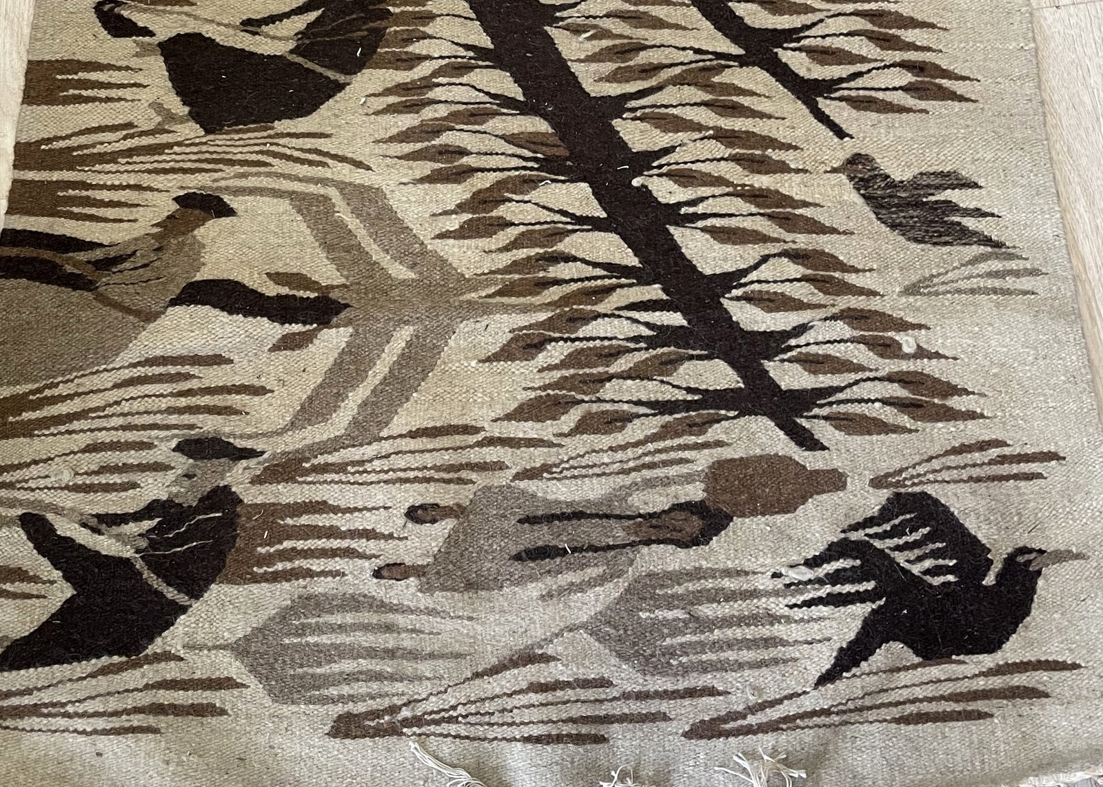 Mid-century flatweave rug from Oaxaca region with charcoal oatmeal and cream geometric design on floor

