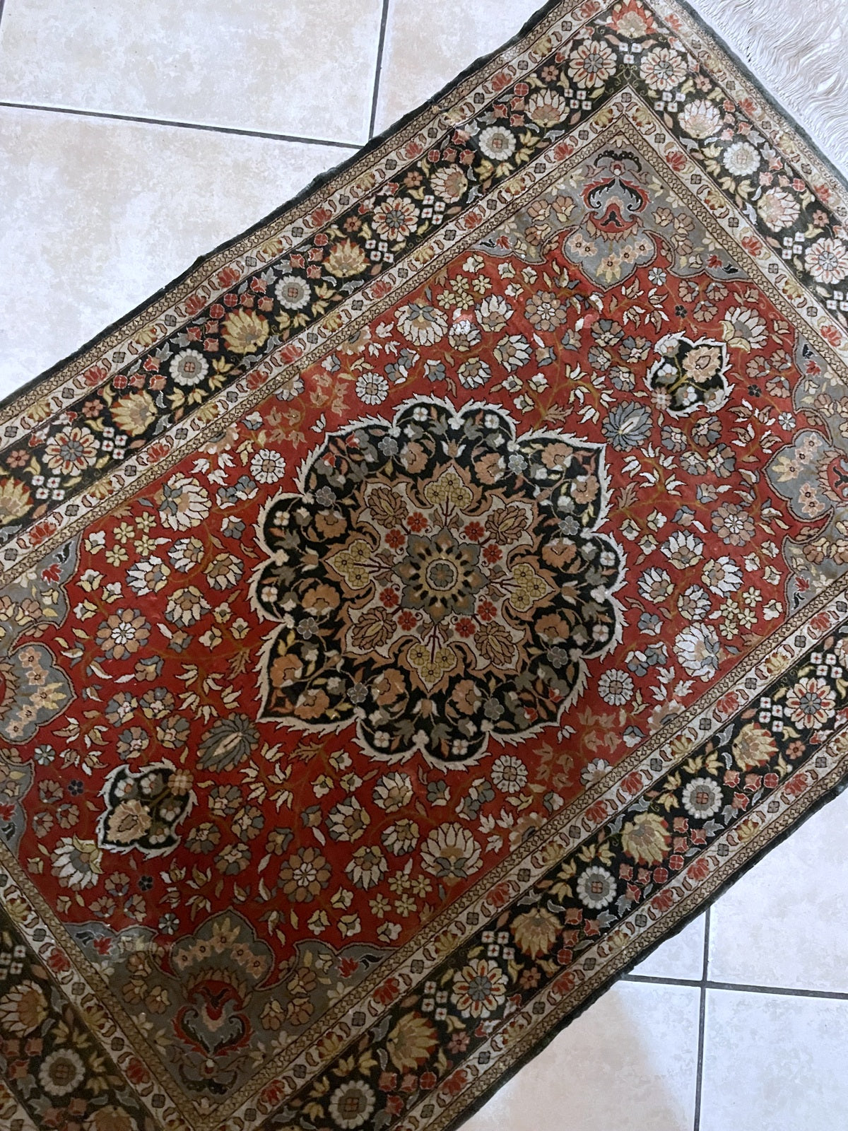 Close-up of vintage silk rug showcasing classic Persian-inspired central medallion and highly detailed floral motifs

