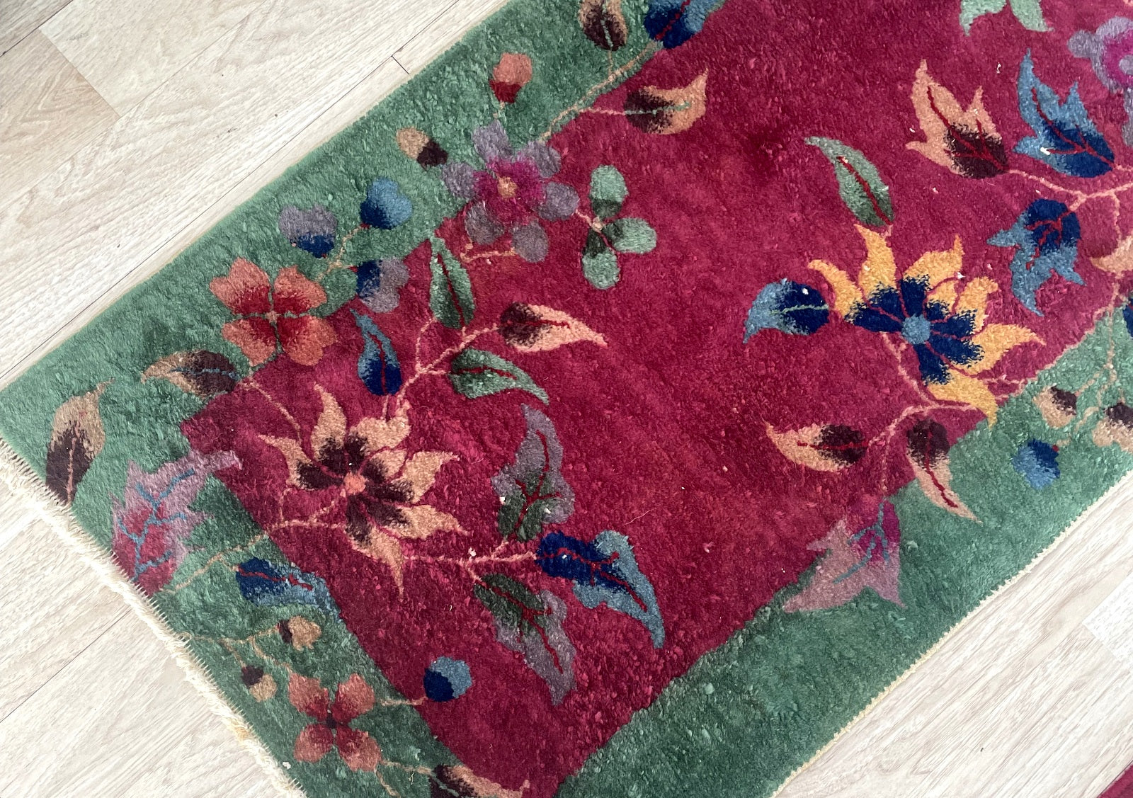 Close-up of antique Chinese Art Deco rug showcasing delicate corner spray of peonies and lotus blossoms in gold and sage

