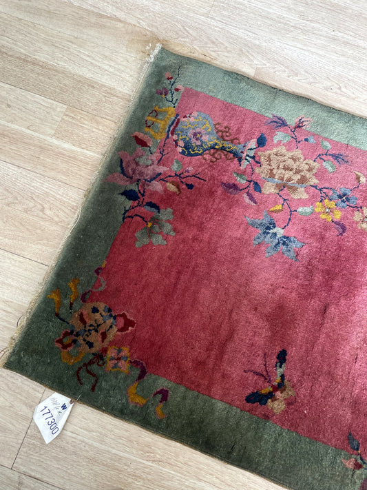 Vintage Nichols style Chinese scatter rug with minimalist floral design and saturated jewel tones on floor

