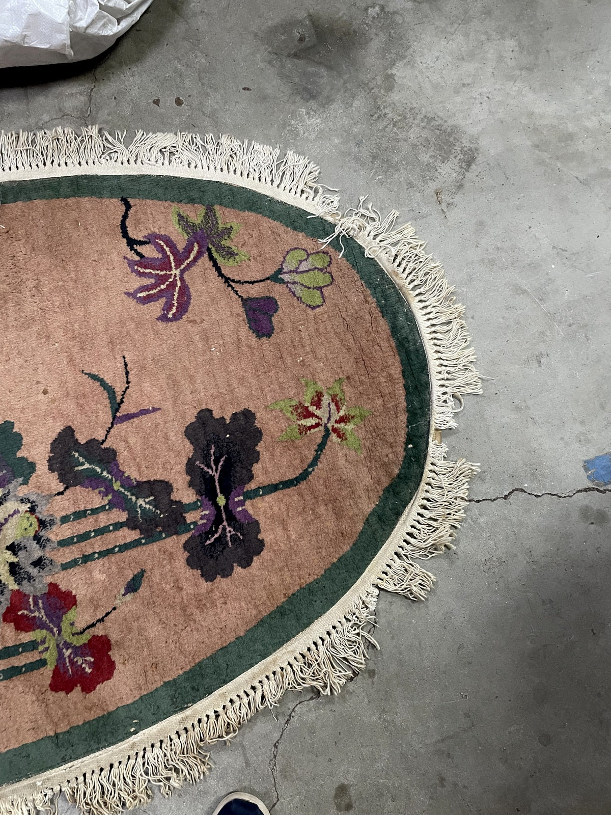 Antique Chinese oval rug close-up, showing hand-knotted wool texture and detail