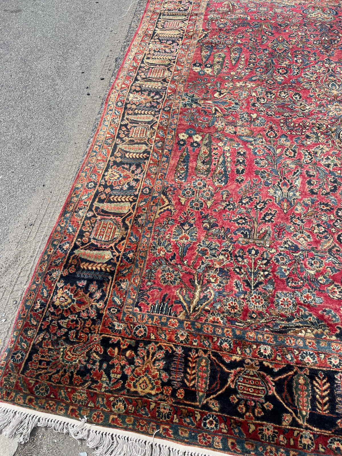 Antique Sarouk rug close-up, showing dense wool pile and intricate floral motifs