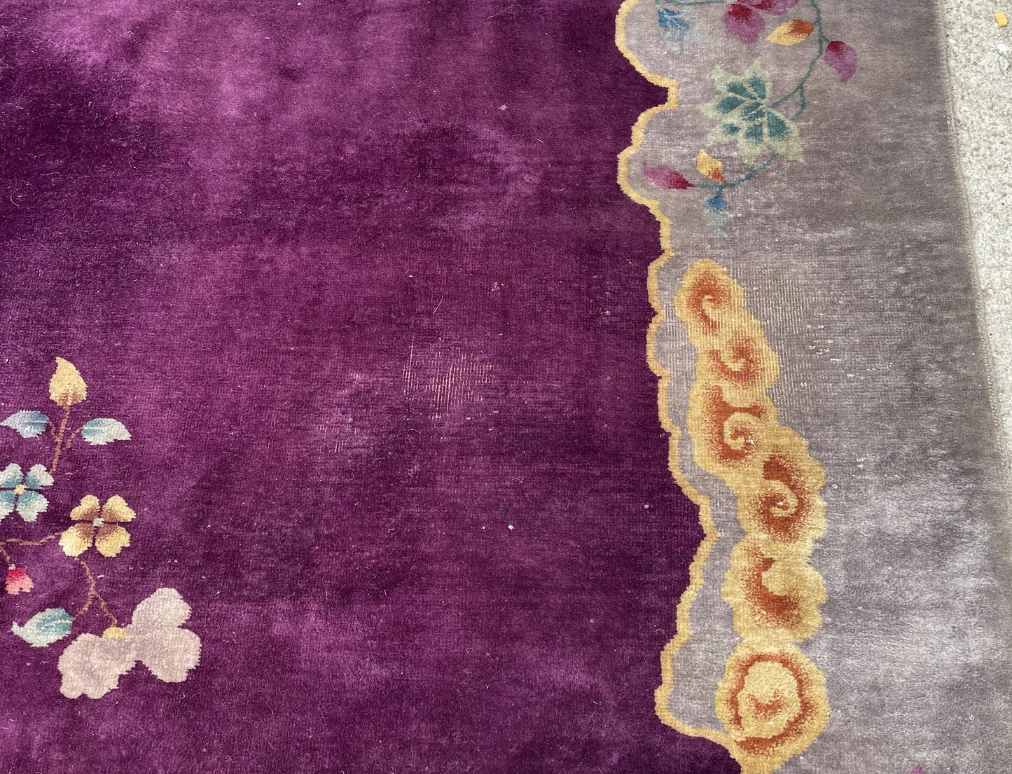 Large antique Chinese Art Deco carpet measuring 8'10" x 11'6" with a rare saturated plum background, scalloped silver-grey cloud border, and golden cloud scroll corners.

