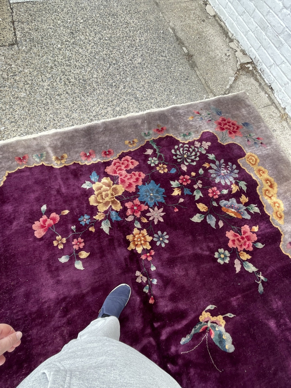 Detail of the scalloped cloud cartouche border on a vintage Chinese Art Deco carpet, showing the silver-grey inner border with undulating gold edge.

