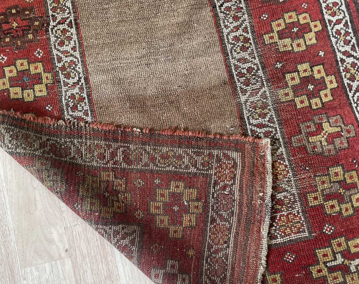 Back view of an antique hand-knotted Kurdish rug revealing the tight, even wool-on-wool foundation with hand-tied knots, characteristic of authentic 19th-century tribal production.

