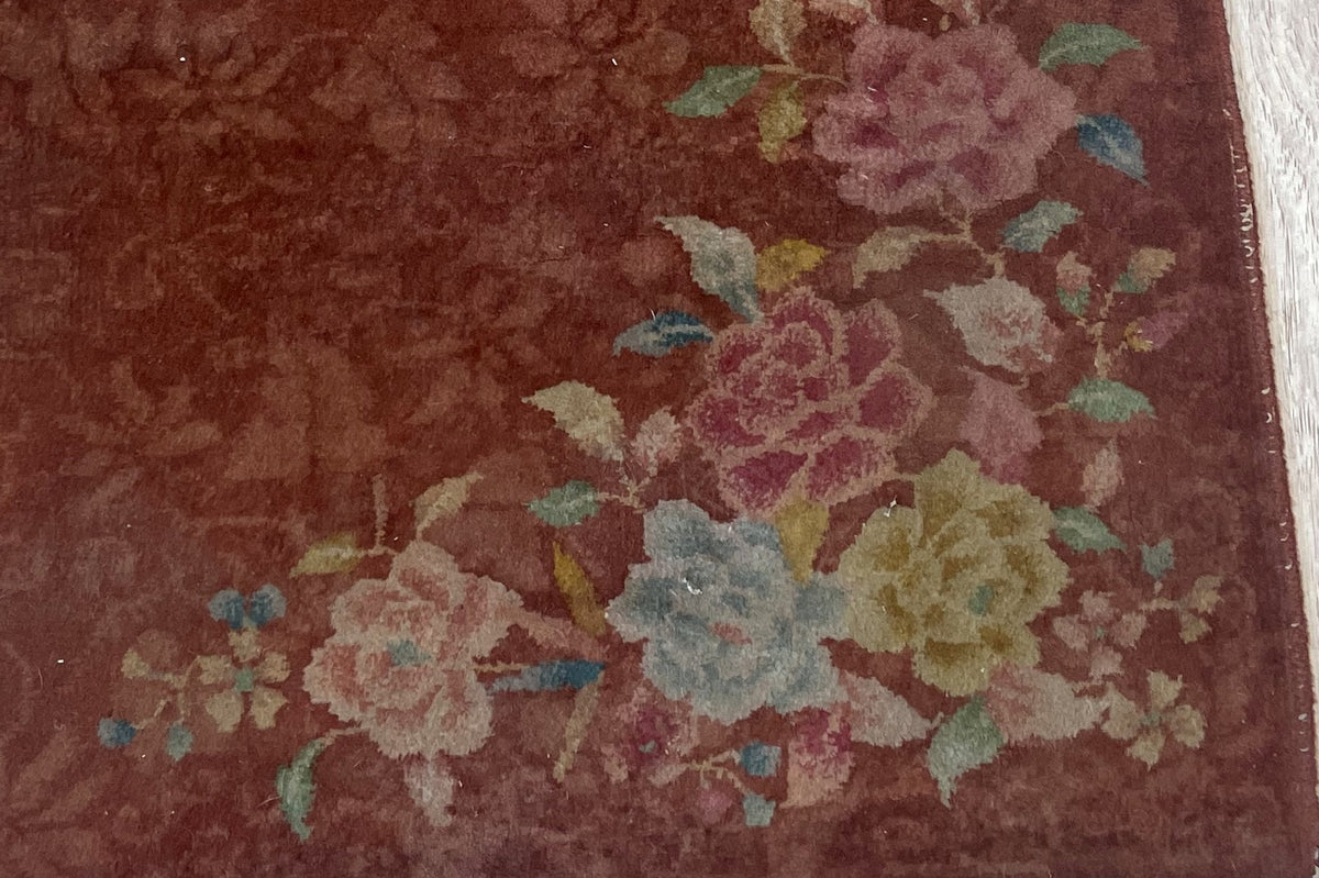 Dusty pink flowers with turquoise-green leaves against rust wool