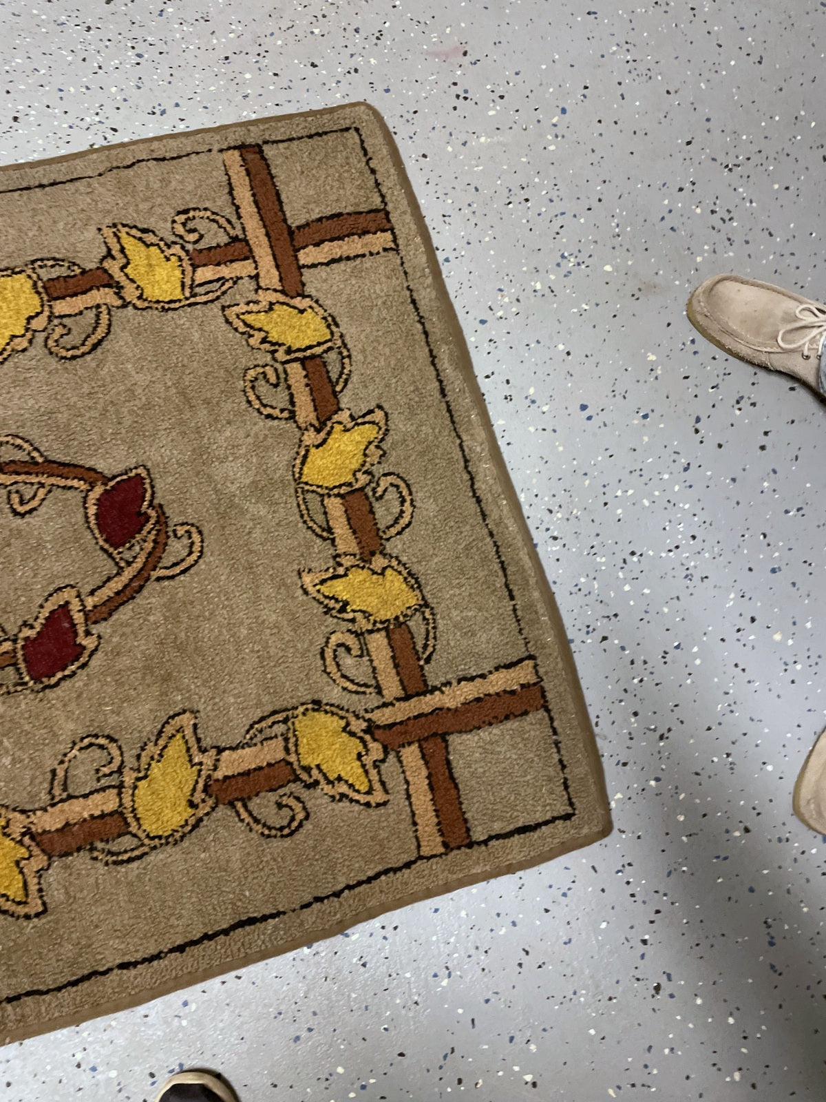 Corner detail showing yellow leaves, crossing brown and cream bands and taupe binding.