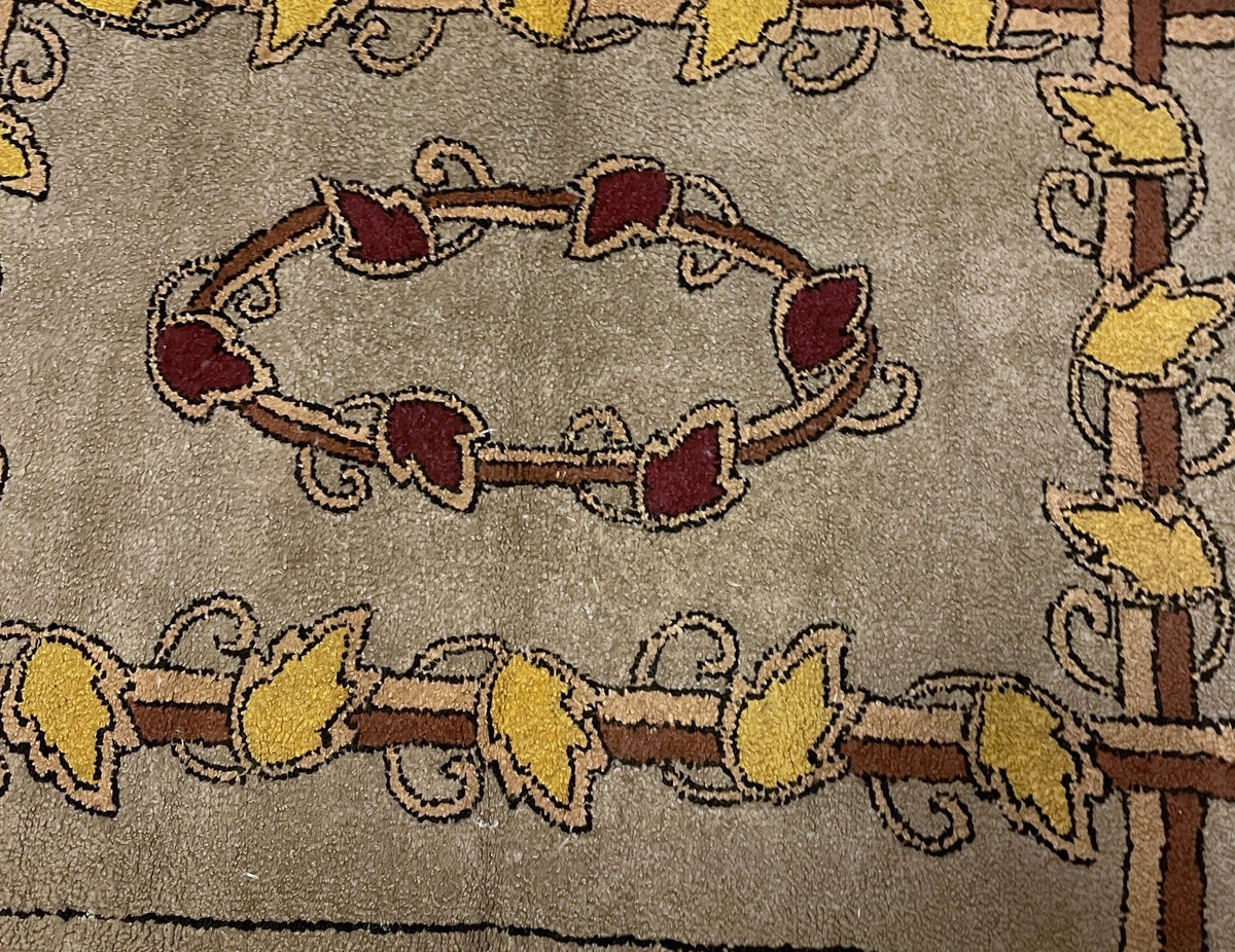 Central burgundy leaf wreath with curling tendrils and surrounding golden foliage.