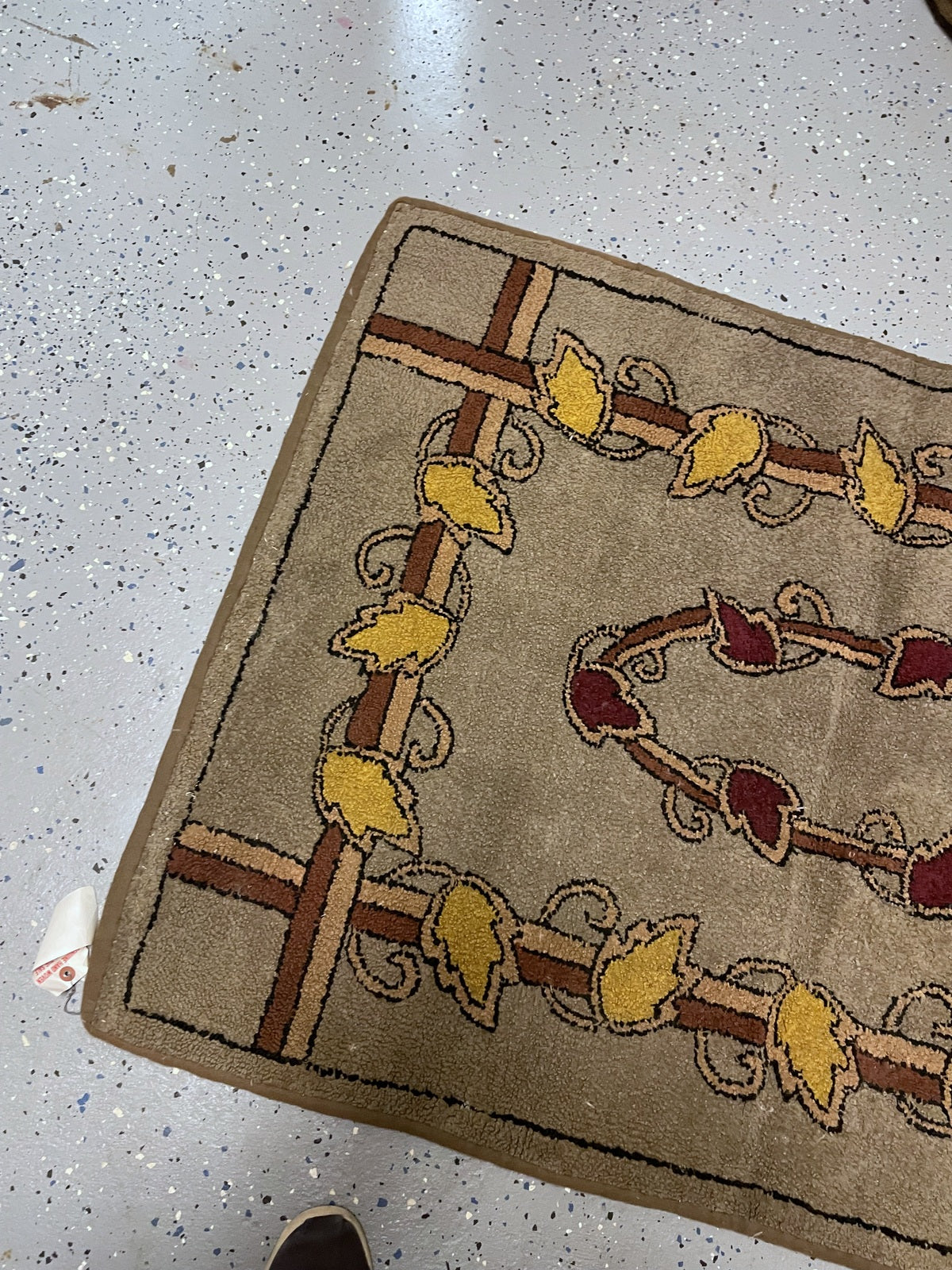 Hooked wool detail showing the yellow leafy frame, cream accents and fine charcoal outlines.