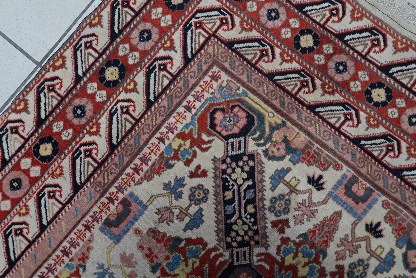 Close-up of the symmetrical navy blue crosses on the handmade vintage Caucasian Zeyhur rug