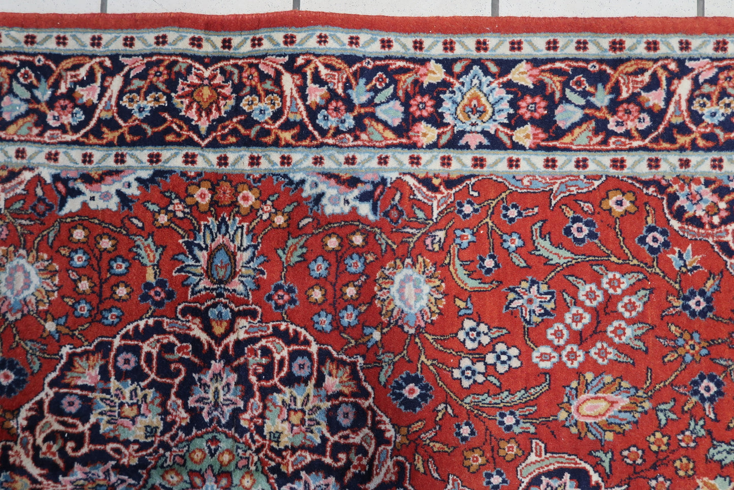 Detailed shot highlighting the vibrant turquoise and navy blue accents on the rug.