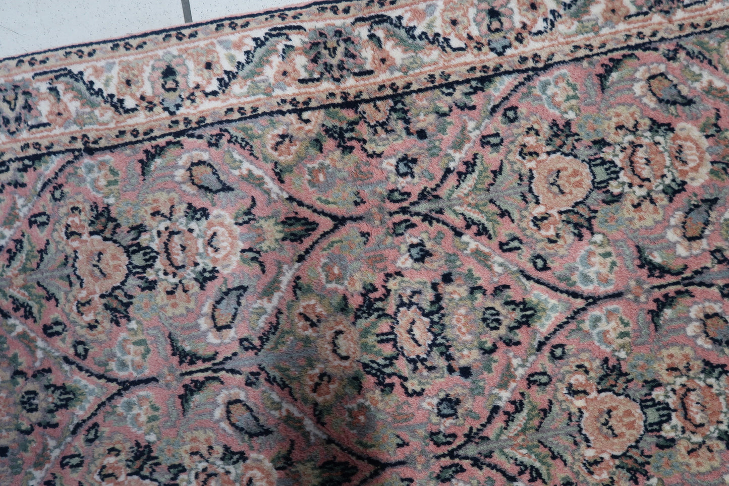 Detailed shot highlighting the beige background and delicate patterns of the rug.