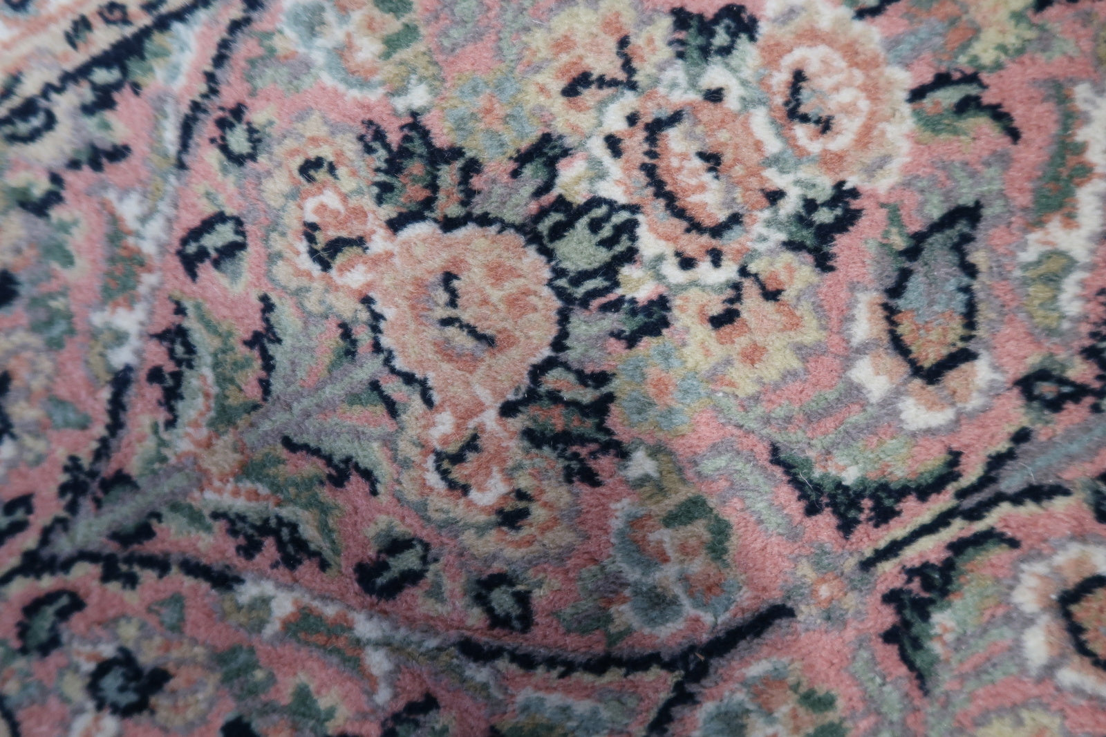 Detailed picture capturing the unique swampy green background and intricate details of the Persian Kerman rug.